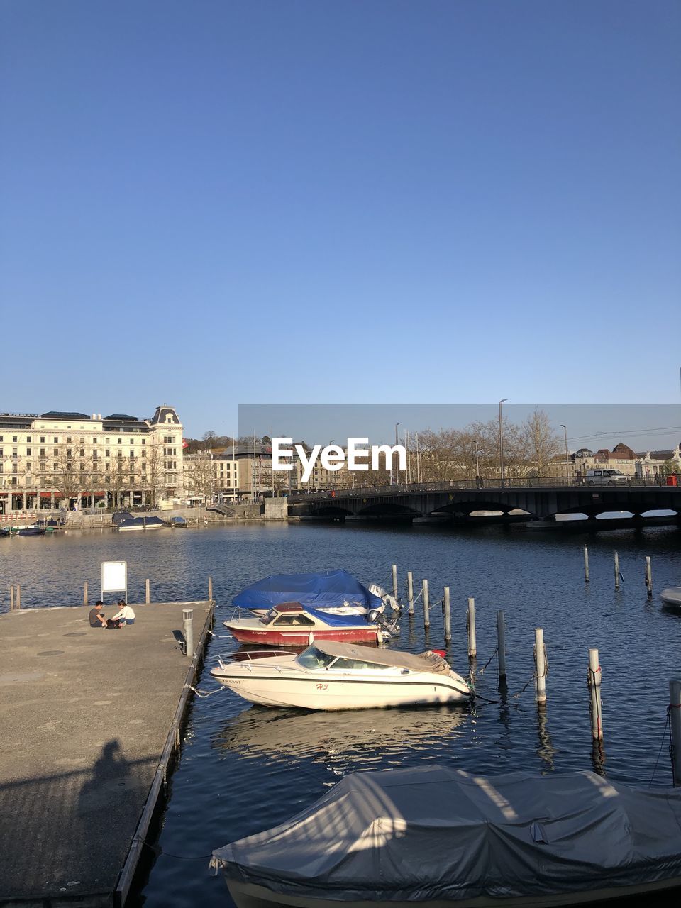 BOATS IN RIVER AGAINST BUILDINGS IN CITY