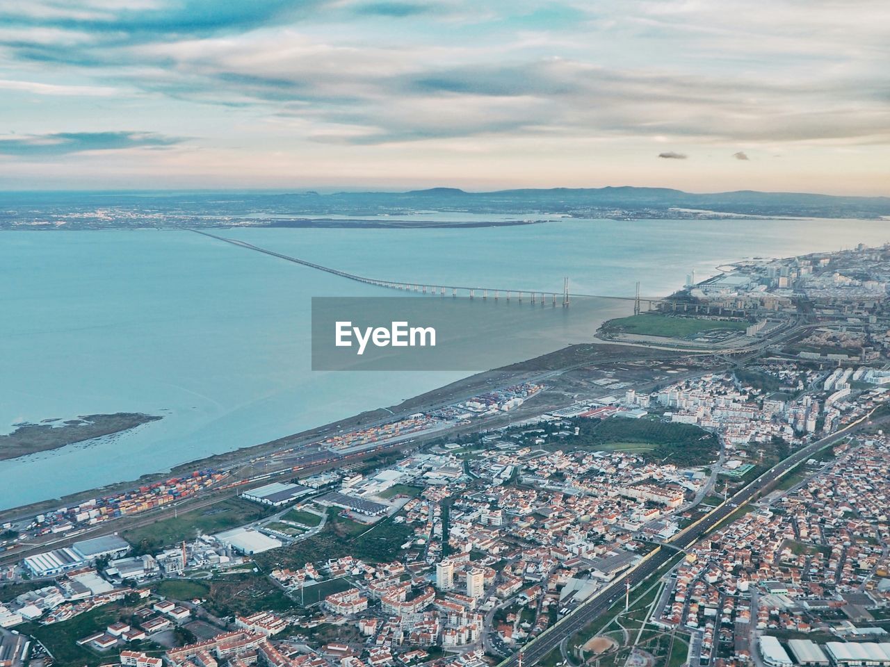 Aerial view of sea and cityscape against sky