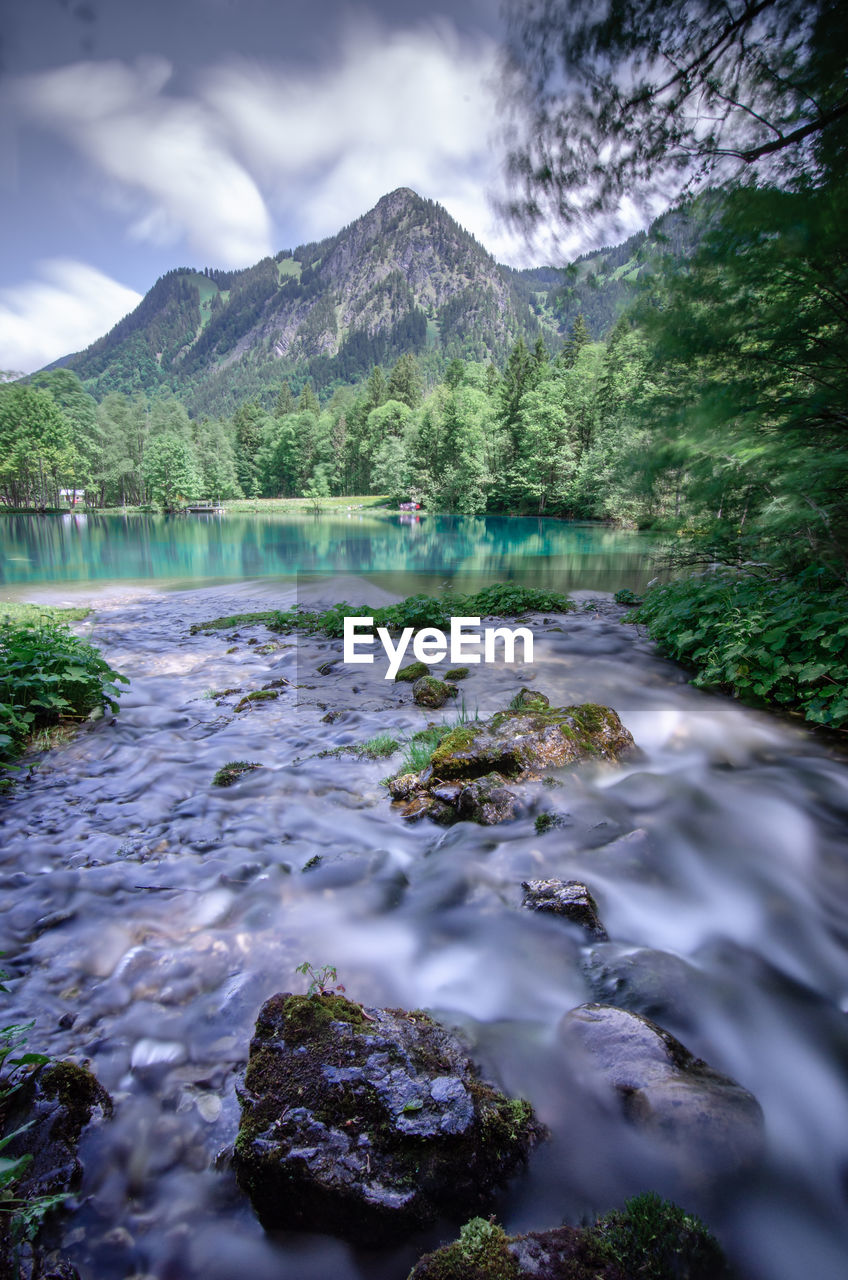 SCENIC VIEW OF RIVER AGAINST MOUNTAINS