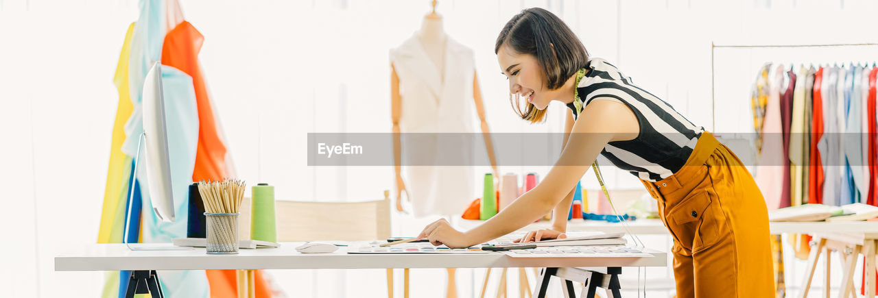 WOMAN WORKING ON TABLE IN OFFICE