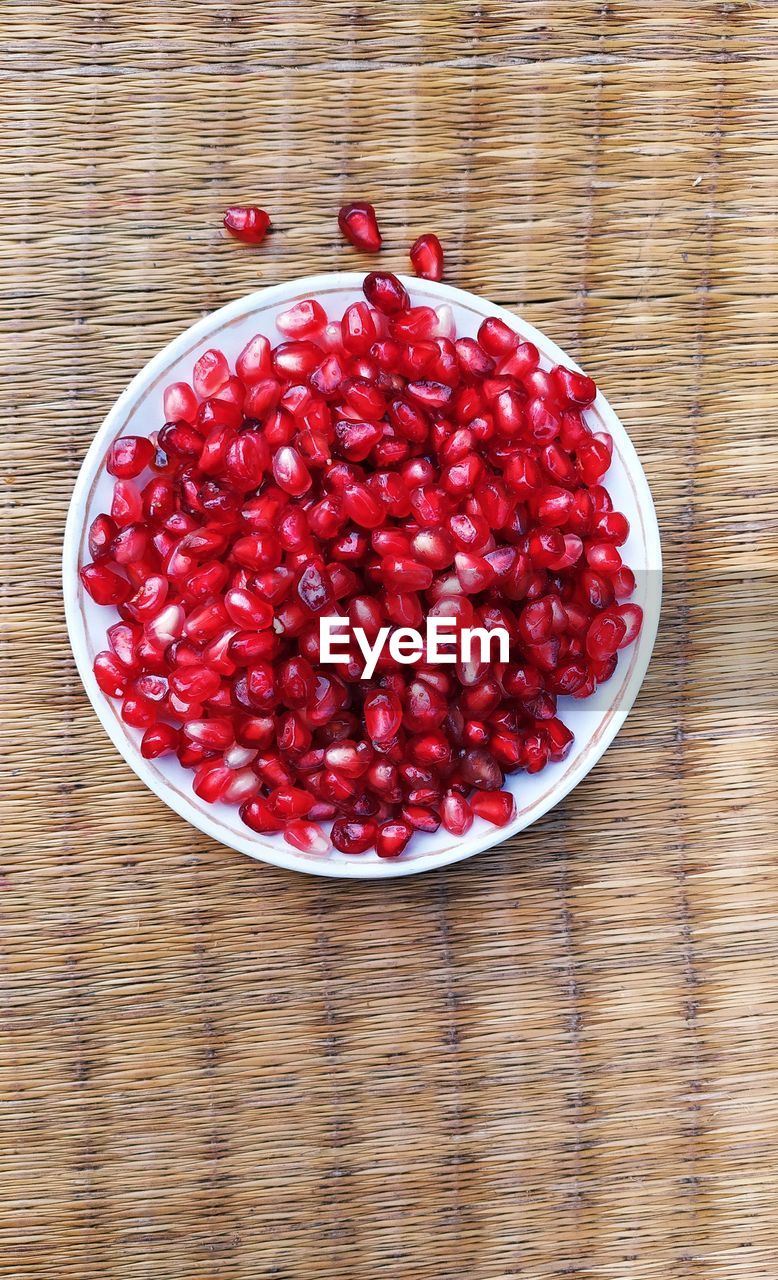 HIGH ANGLE VIEW OF RASPBERRIES IN BOWL ON TABLE