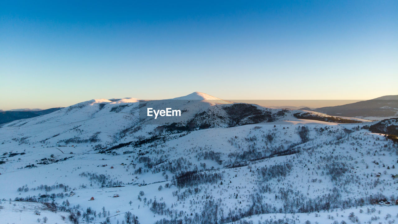 Scenic view of snowcapped mountains against clear sky