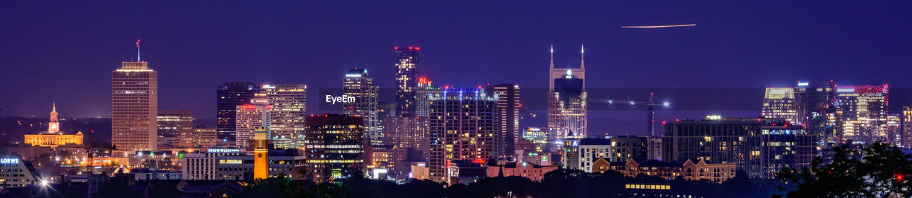 Panoramic view of illuminated buildings against sky at night