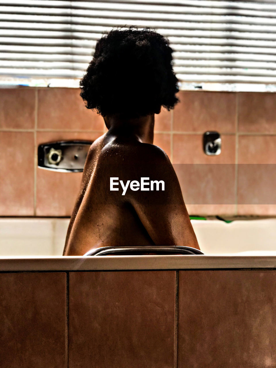 African nude woman on a bath. south african model with natural hair.