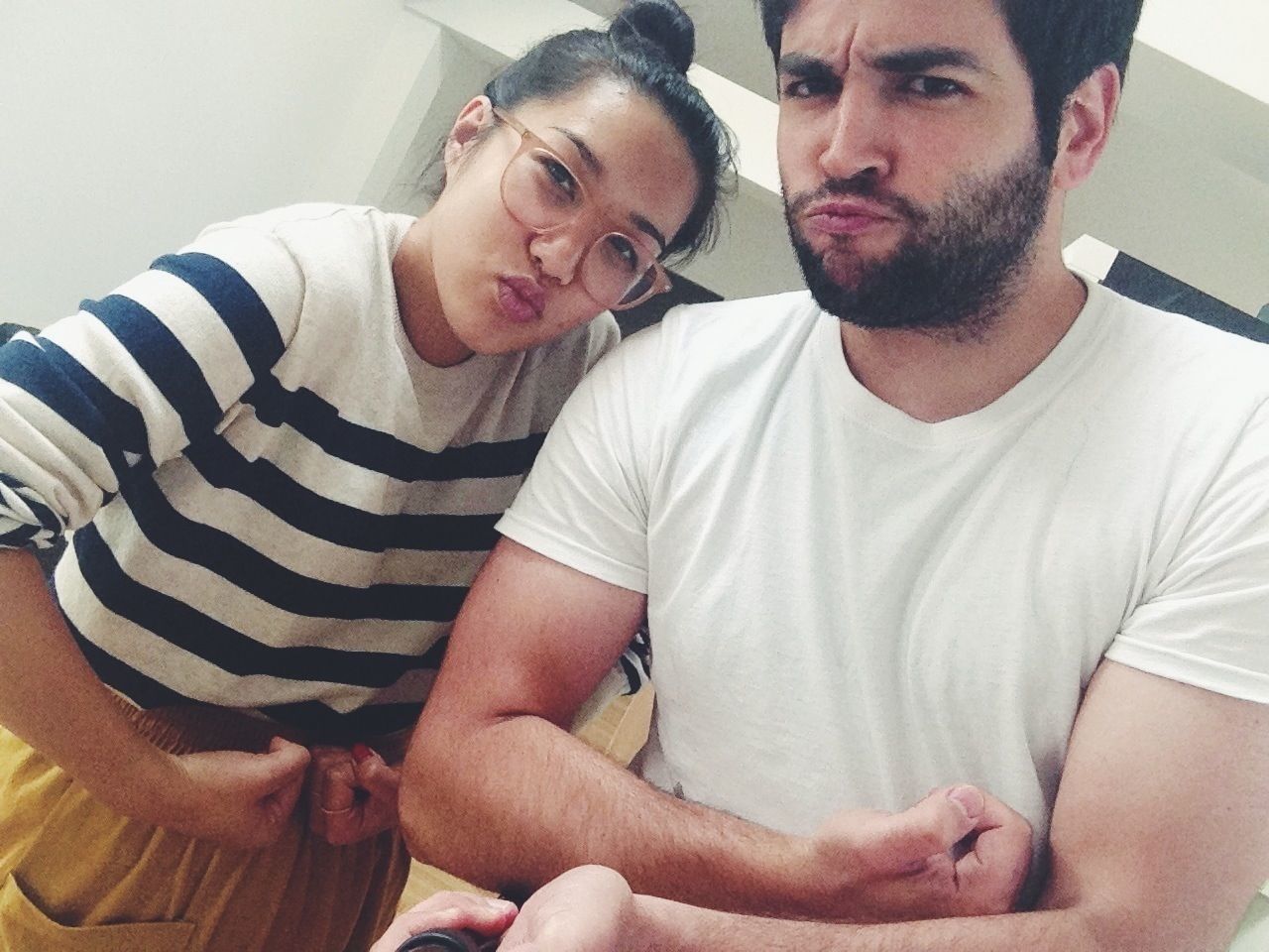 Portrait of young couple flexing muscles