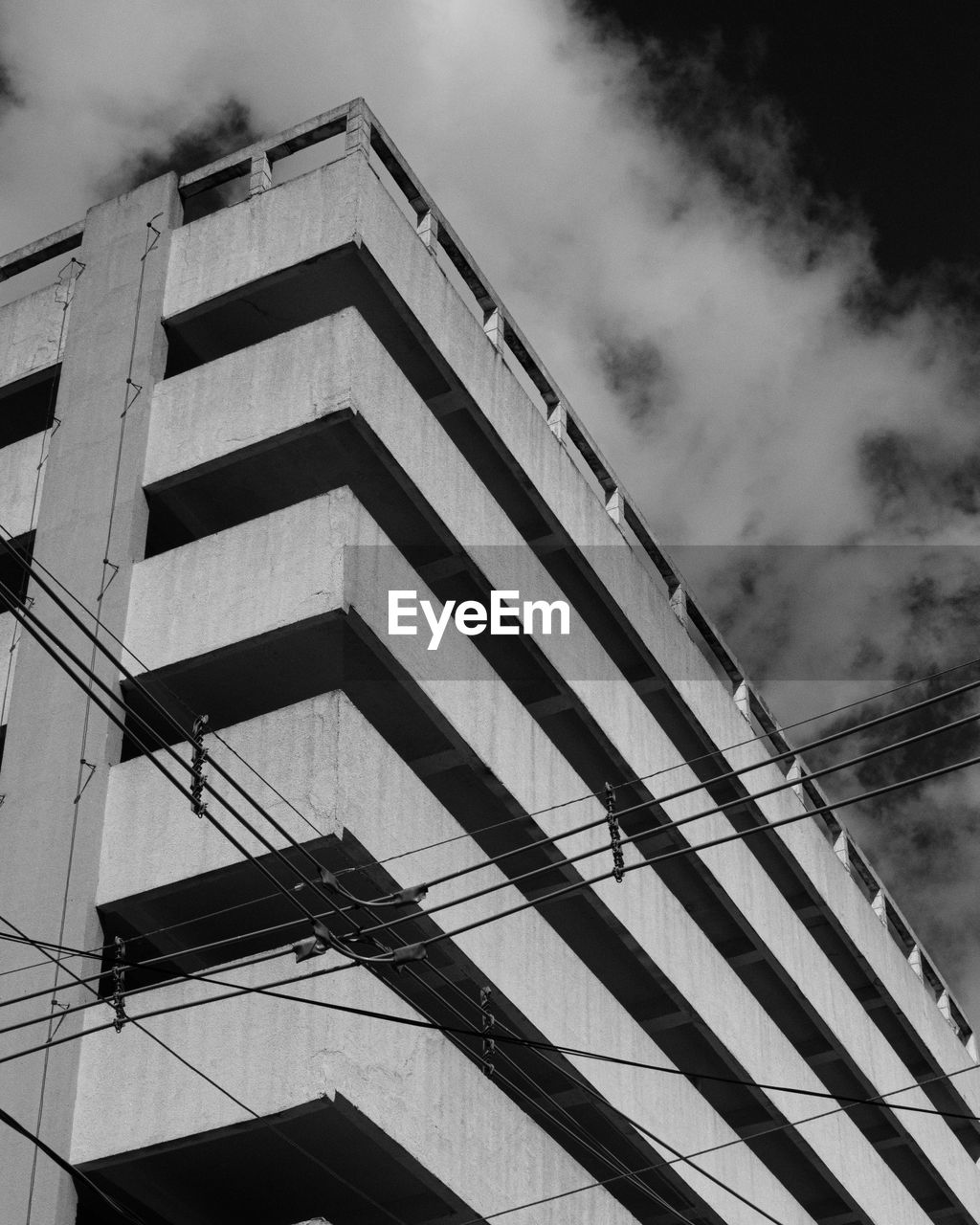 LOW ANGLE VIEW OF BUILDING AGAINST CLOUDY SKY