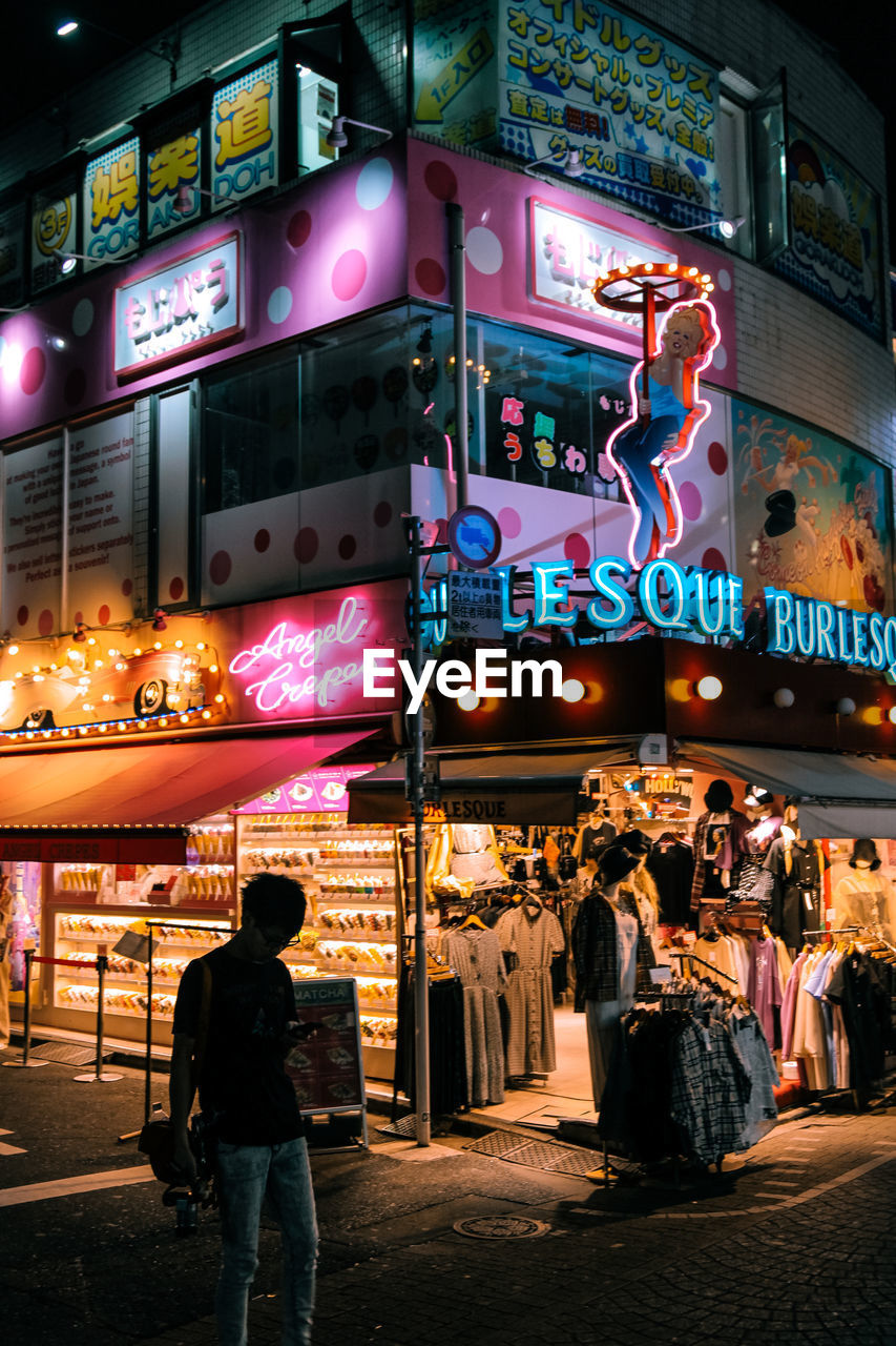 FULL LENGTH OF PEOPLE ON ILLUMINATED STREET AT NIGHT