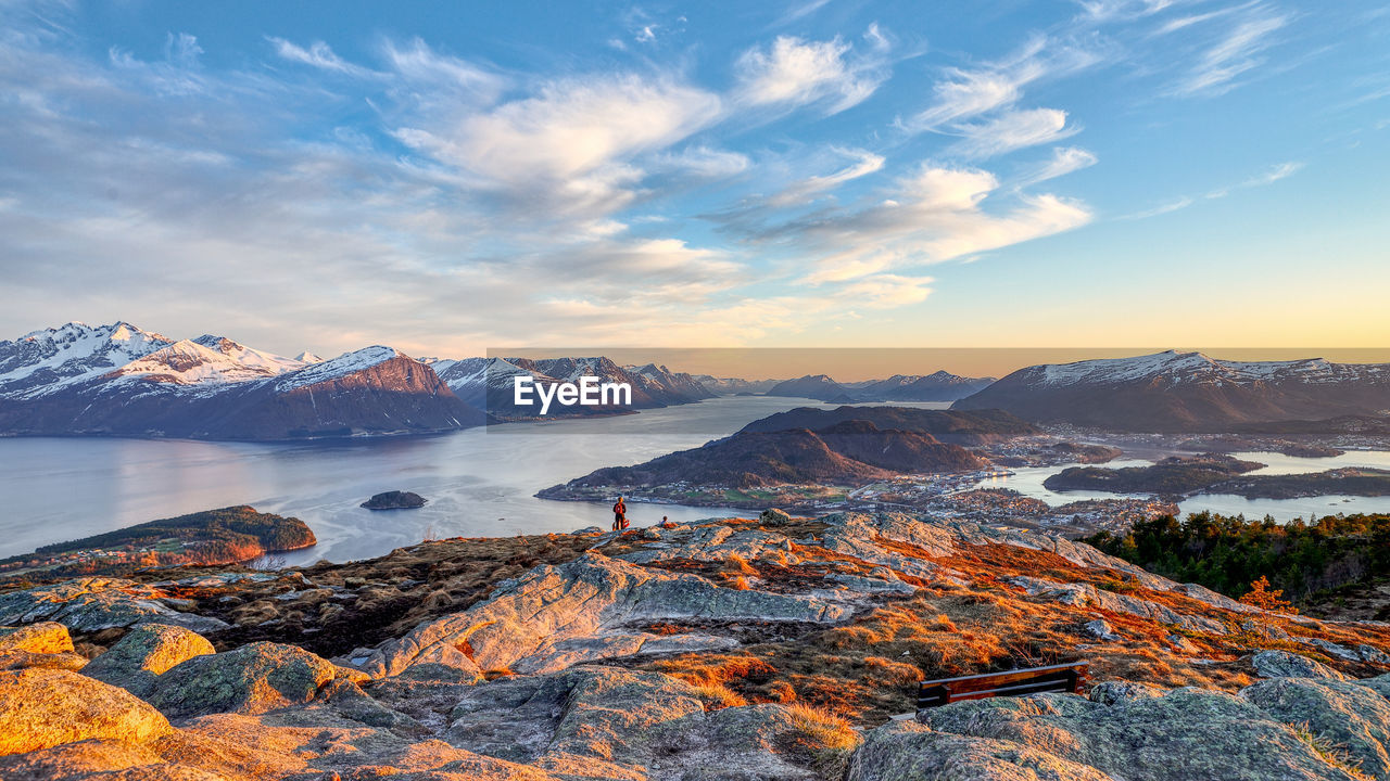 Scenic view of mountains and river against sky during sunset