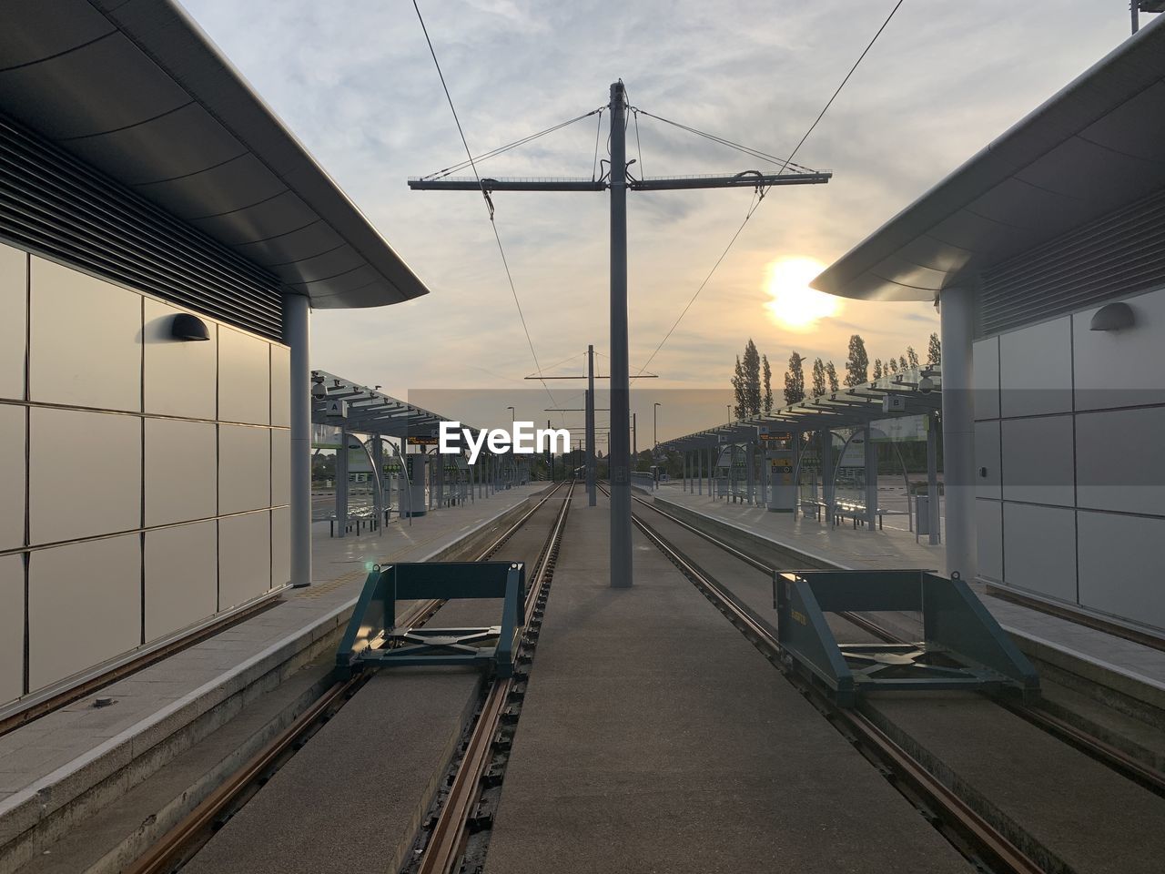 RAILROAD TRACKS AGAINST SKY AT SUNSET