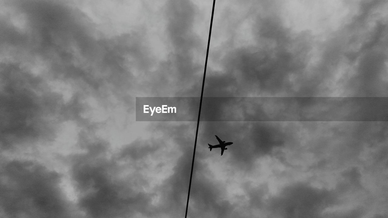 Low angle view of silhouette airplane against sky