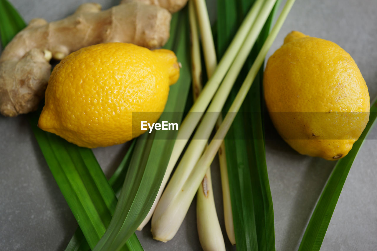 High angle view of lemon with ginger and vegetables on table