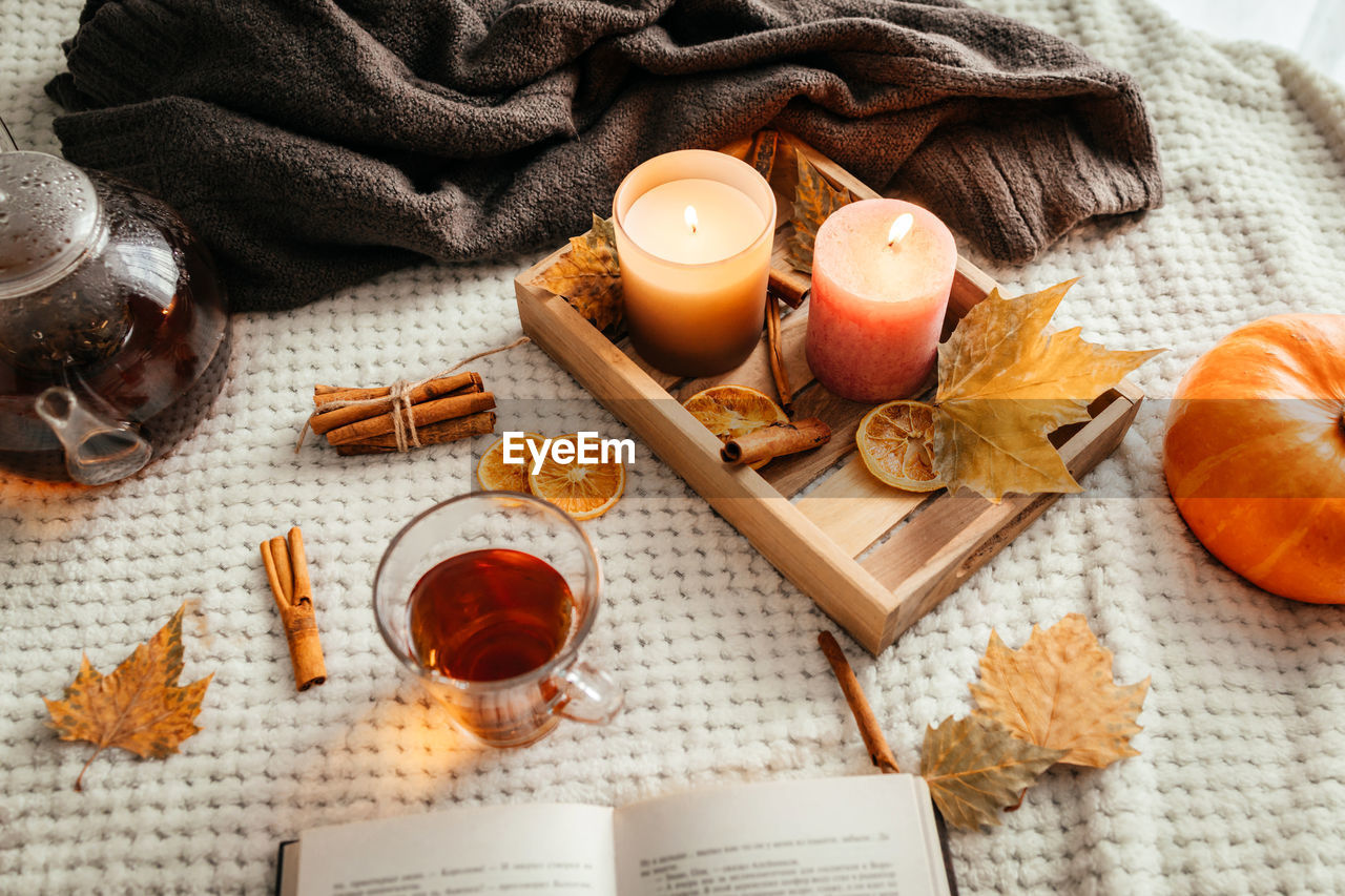 Cozy autumn atmospheric composition. sveti, a pumpkin, hot tea and an open notepad 