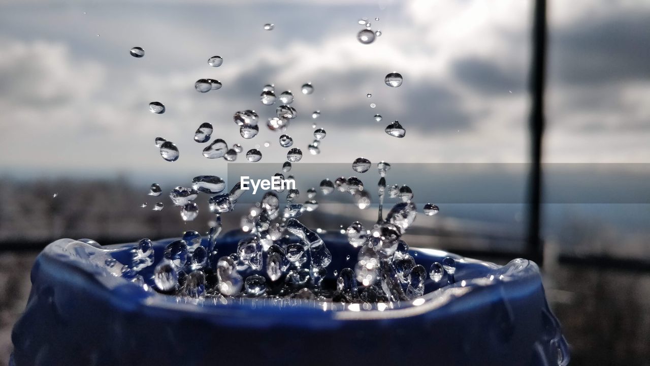 CLOSE-UP OF WATER SPLASHING ON GLASS