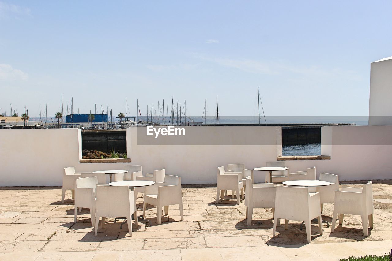 VIEW OF CHAIRS AND CITYSCAPE AGAINST SKY