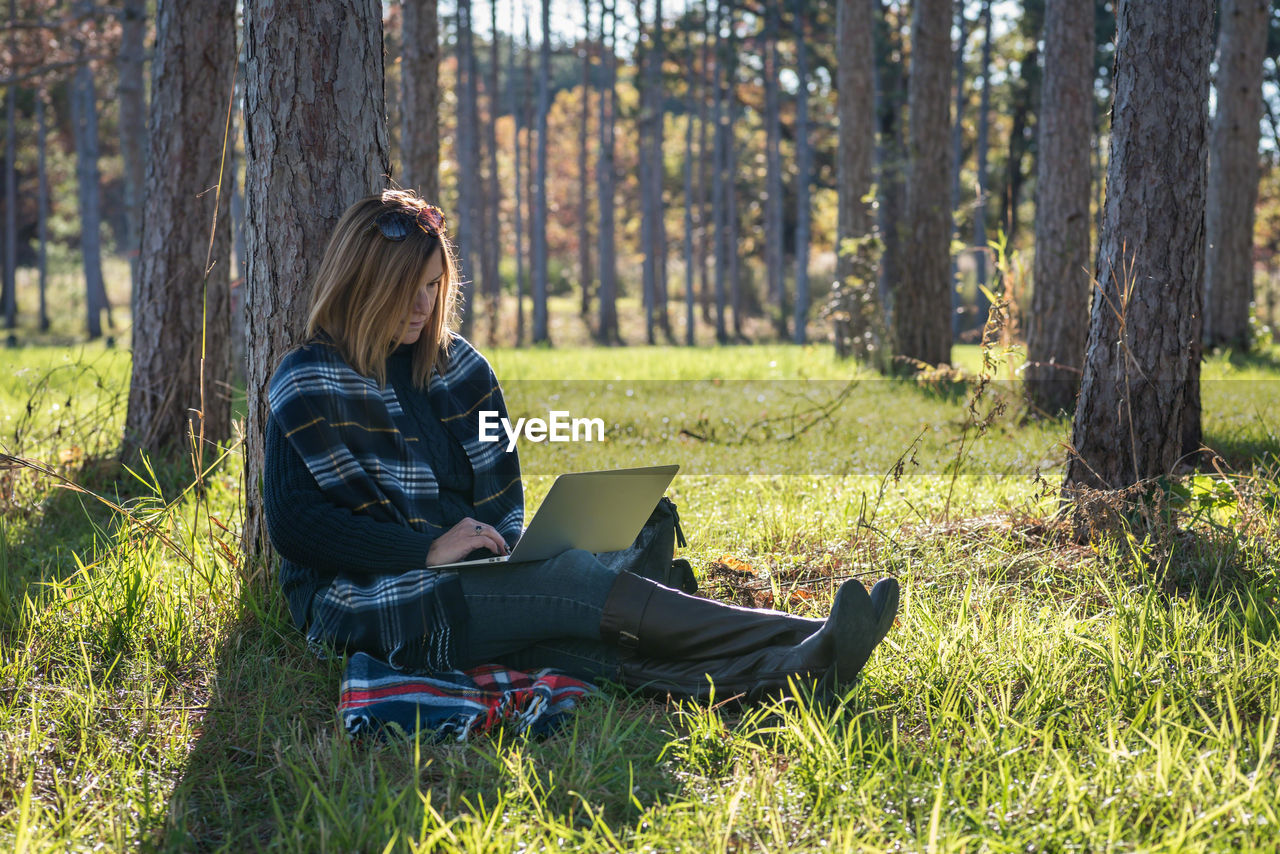 Woman using laptop at park