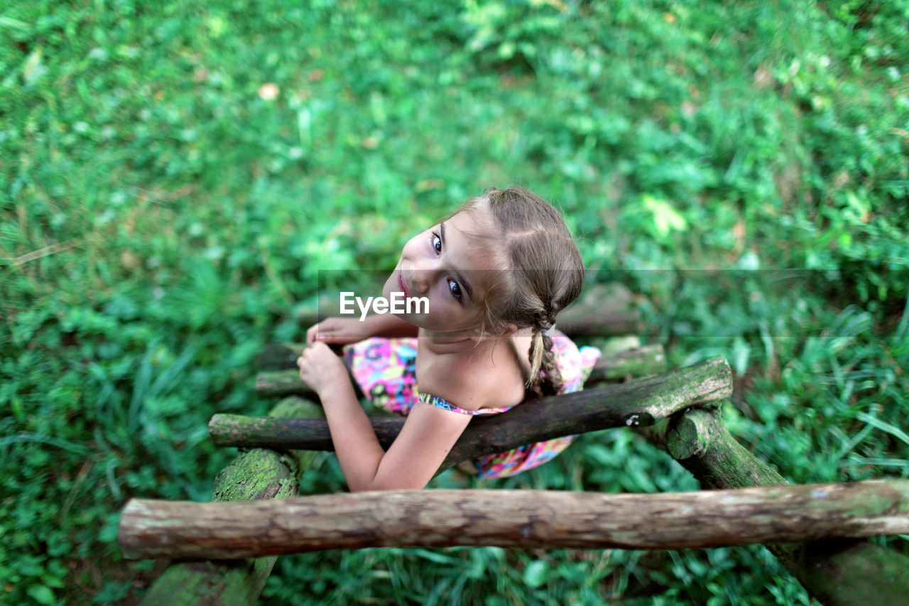 Girl sitting on wood