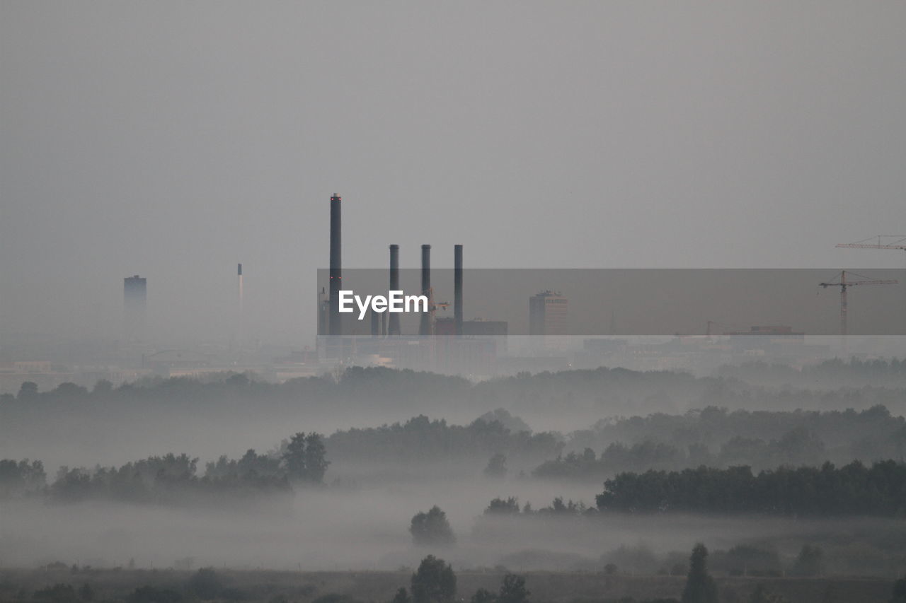 Smoke stacks in factory against sky