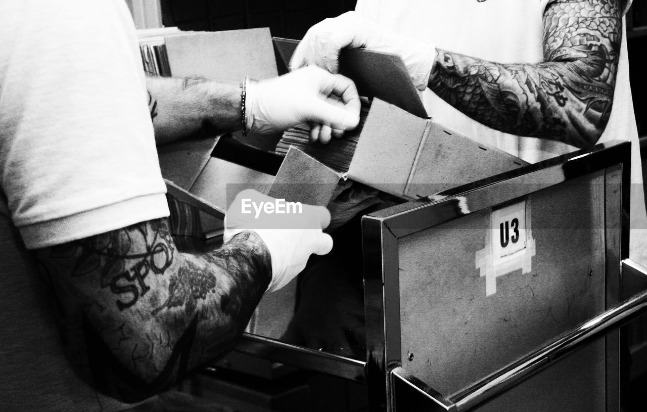 HIGH ANGLE VIEW OF MAN HOLDING TEXT ON FLOOR