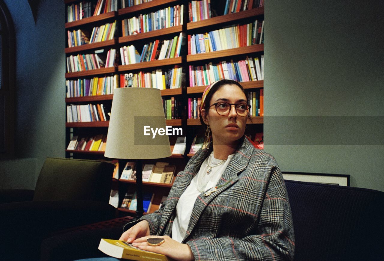 Woman looking away while sitting in library