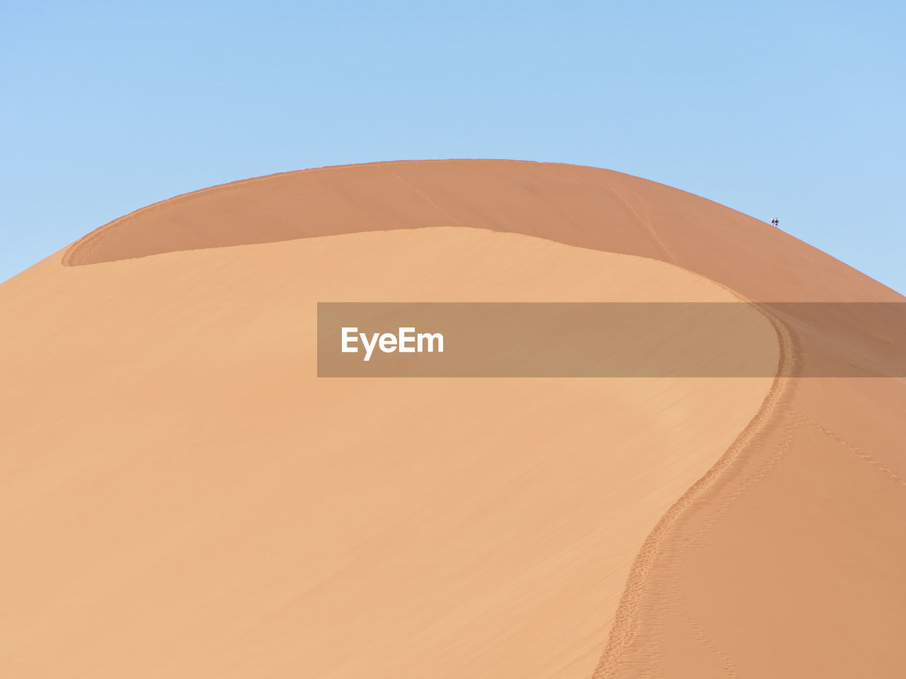 Sand dunes in desert against clear sky