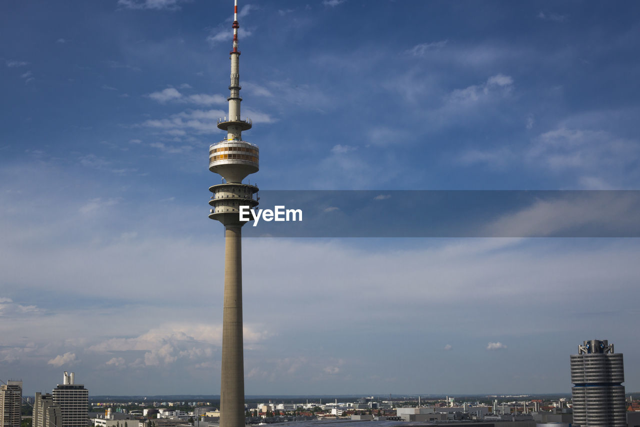 COMMUNICATIONS TOWER AGAINST CLOUDY SKY AT CITY