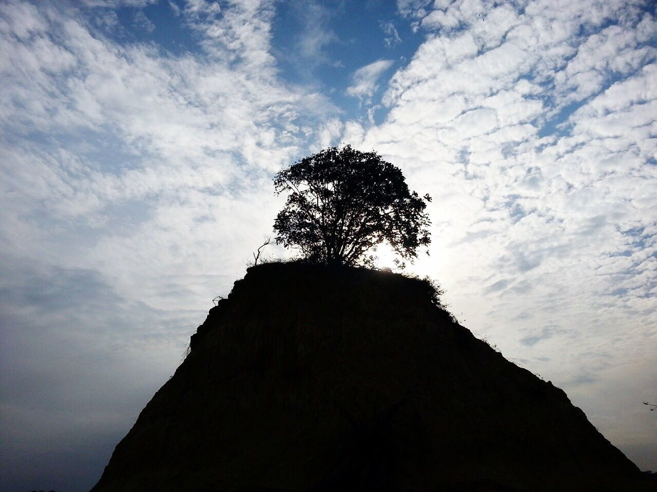 Low angle view of mountain against cloudy sky