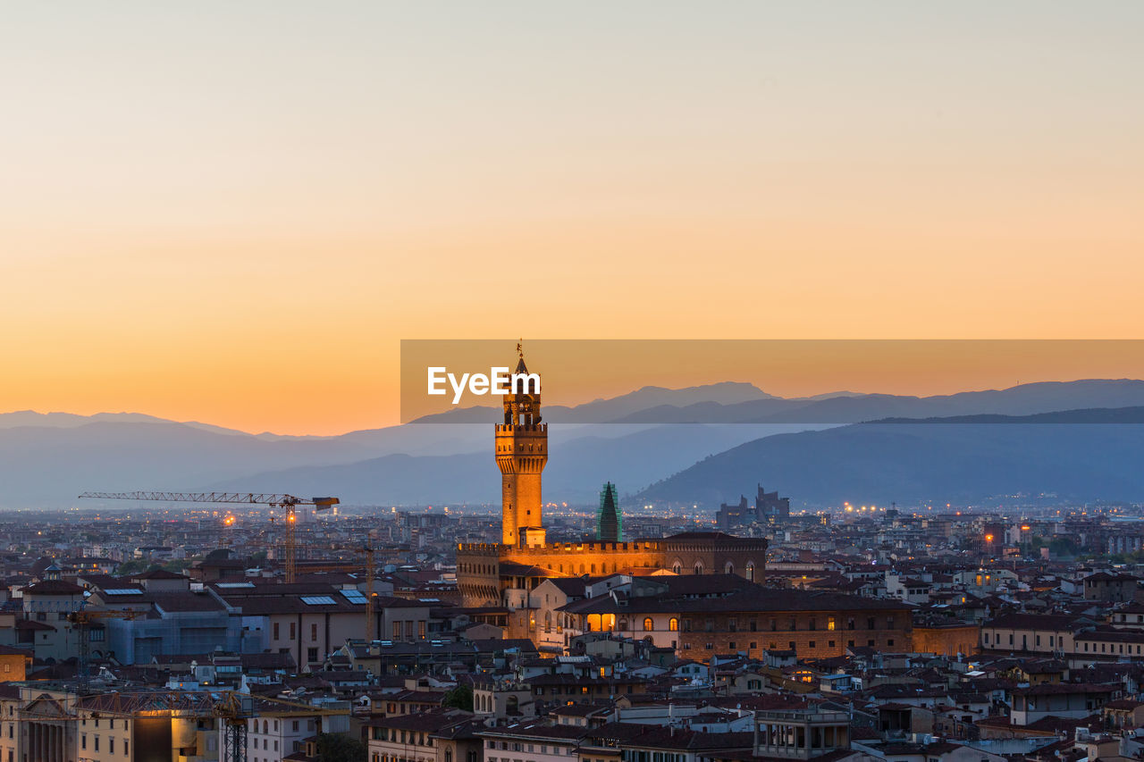 Illuminated buildings in florence city against sky during sunset