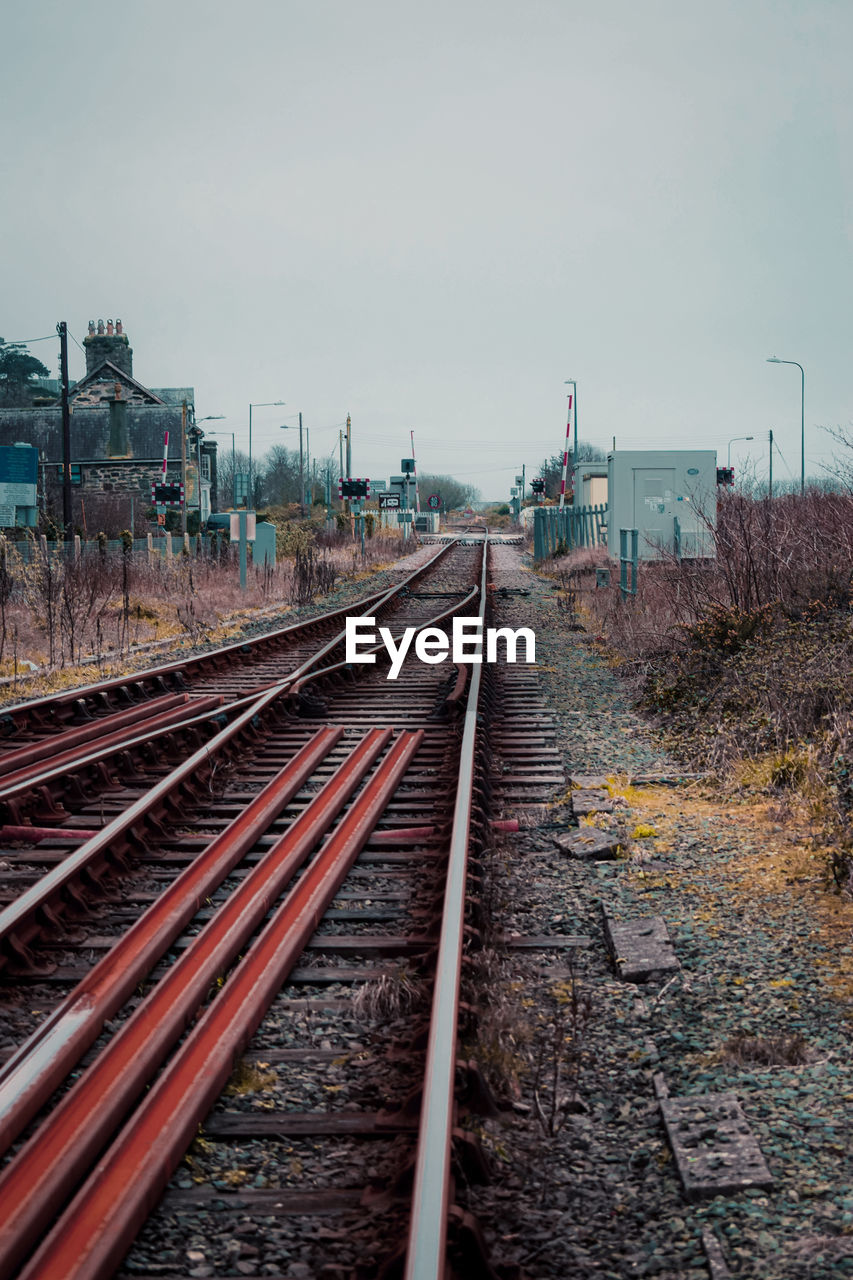 Railroad tracks against cloudy sky