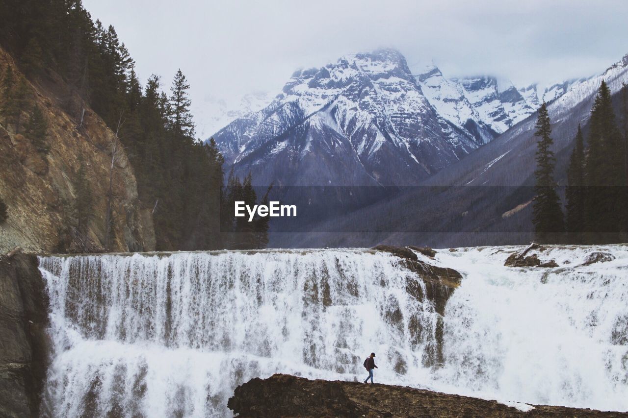 Scenic view of waterfall against sky during winter