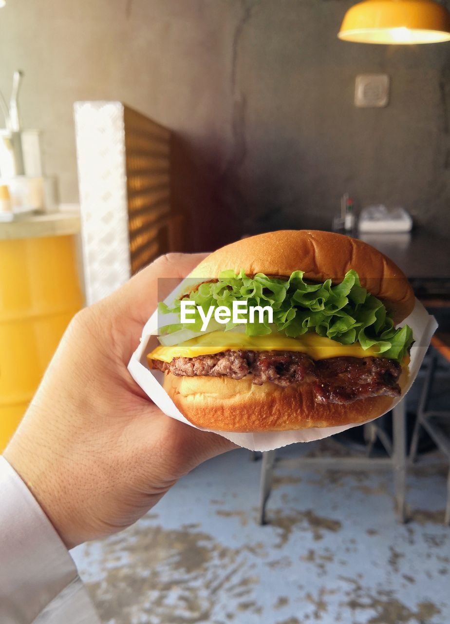 Cropped hand holding burger