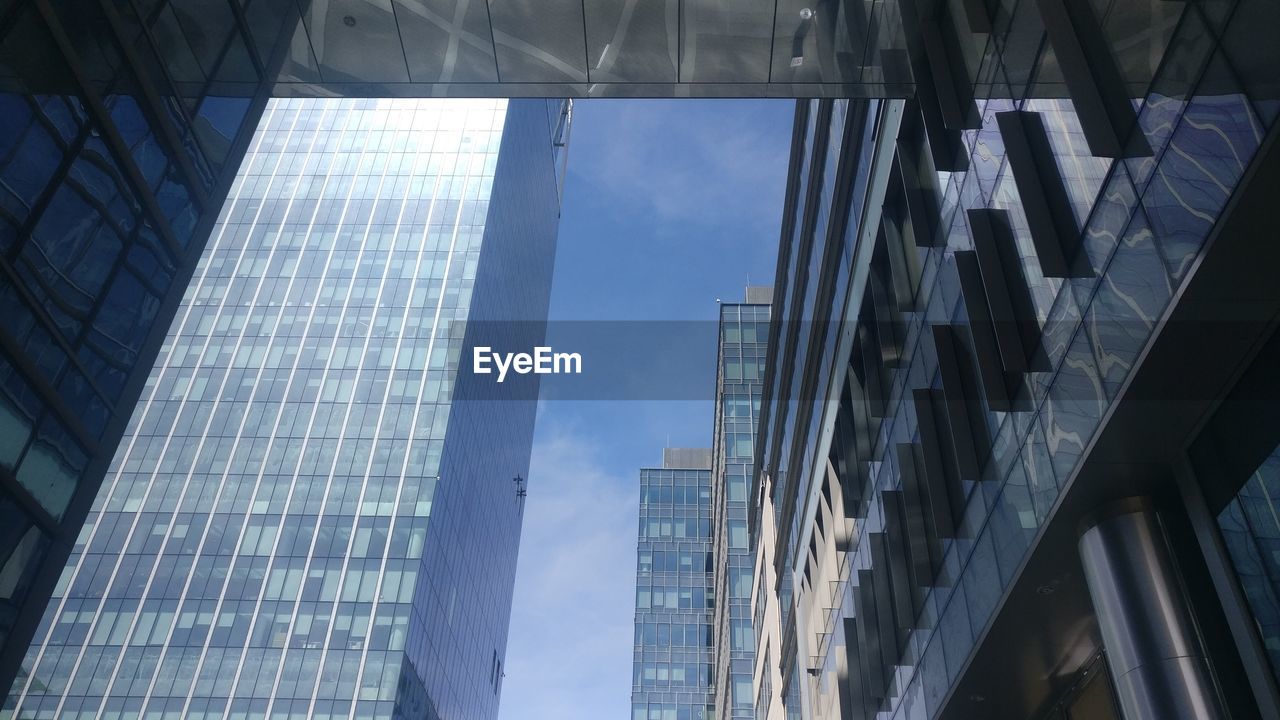 LOW ANGLE VIEW OF GLASS BUILDING AGAINST SKY