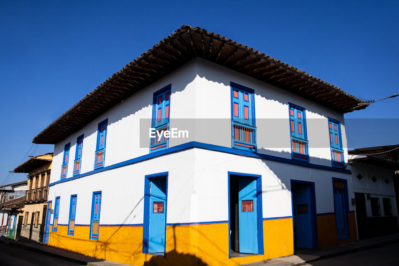 architecture, building exterior, built structure, building, blue, facade, house, sky, city, no people, clear sky, multi colored, window, nature, residential district, travel destinations, outdoors, street, town, urban area, day, travel