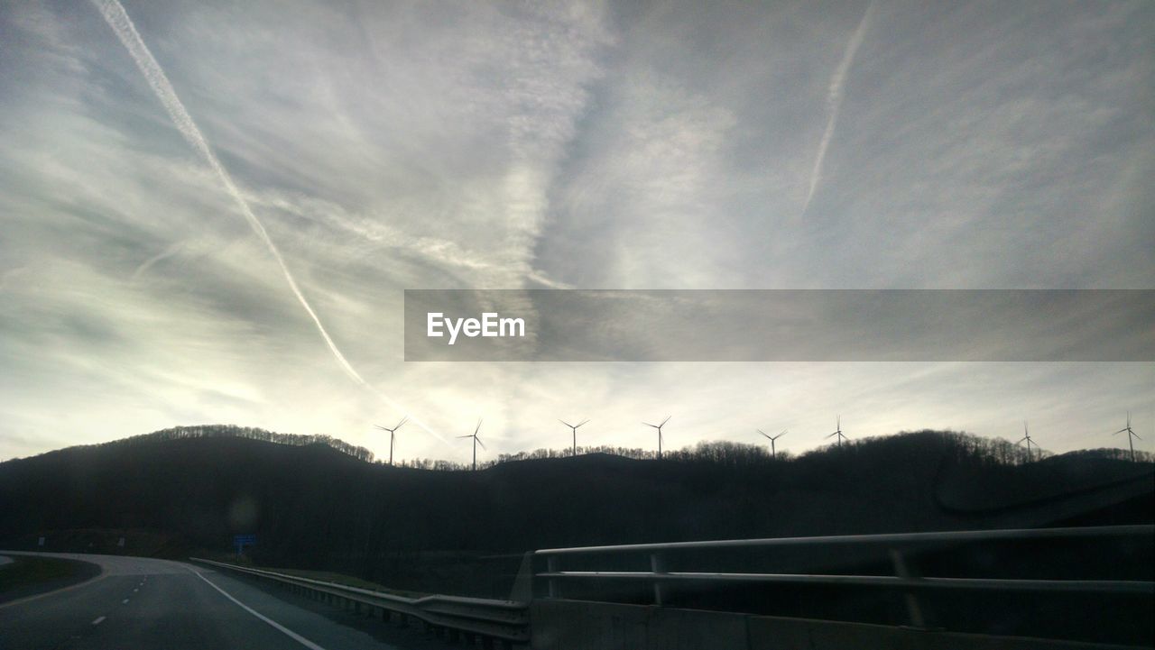 View of windmill farm against sky