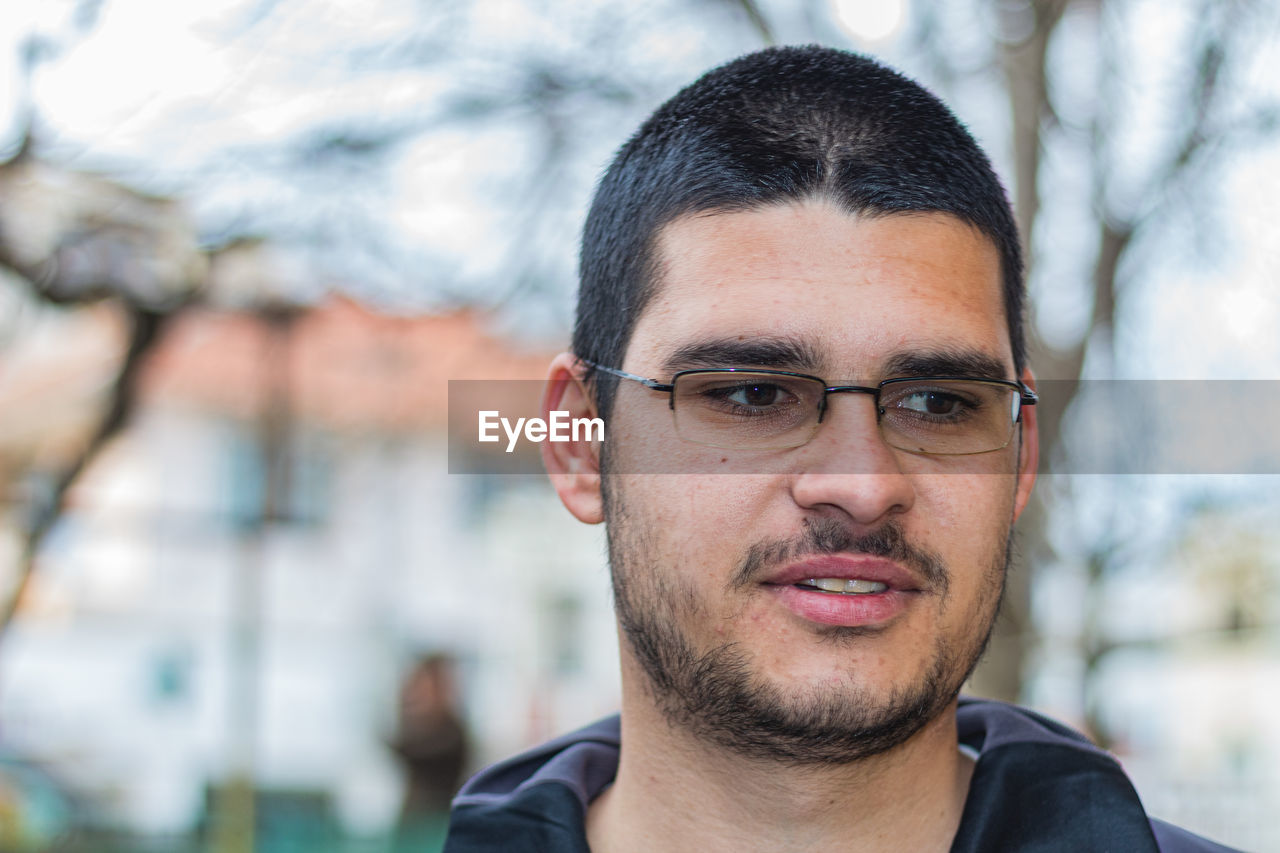 PORTRAIT OF YOUNG MAN WITH EYEGLASSES