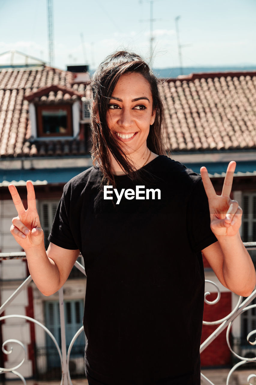 Young woman looking at camera with positive attitude on a rooftop.