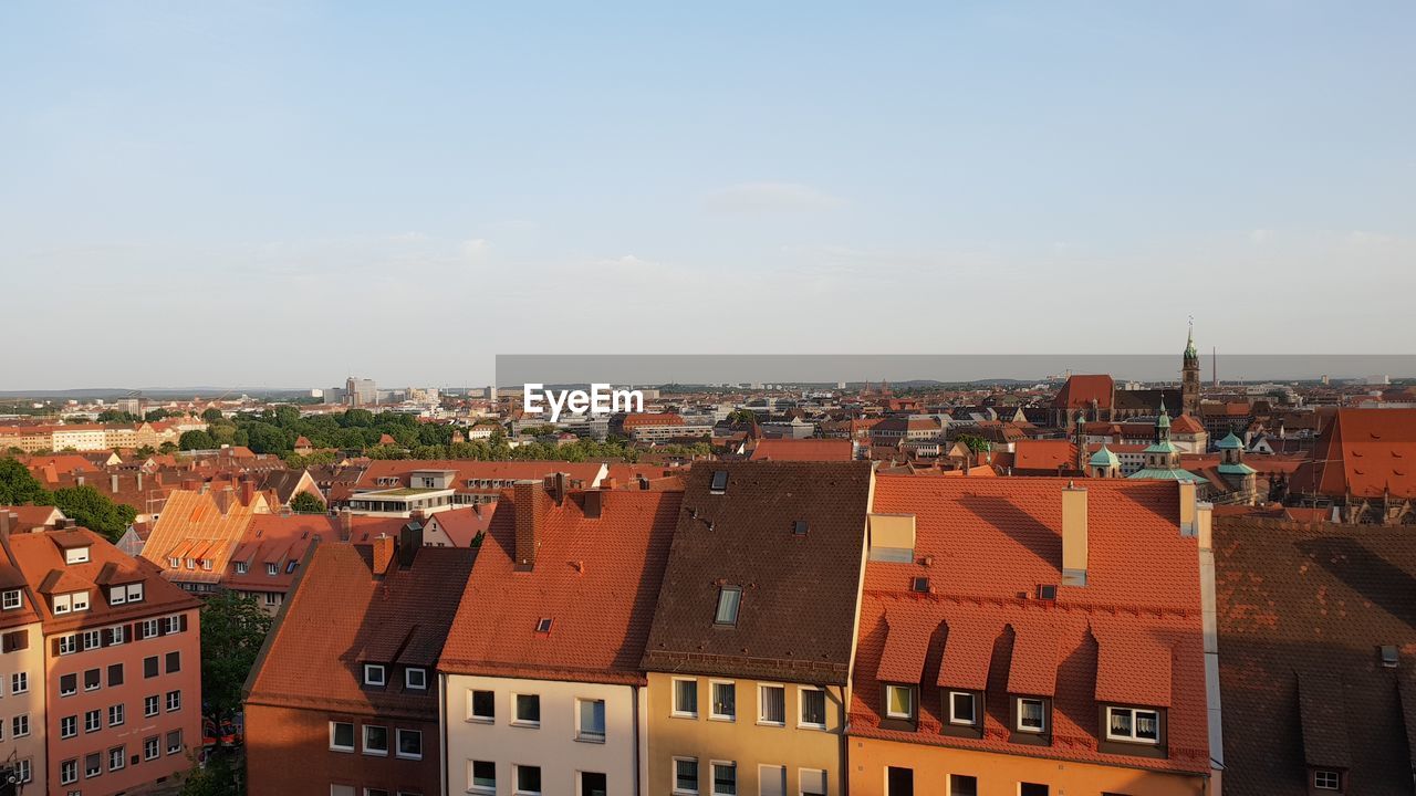 HIGH ANGLE VIEW OF HOUSES IN TOWN AGAINST SKY