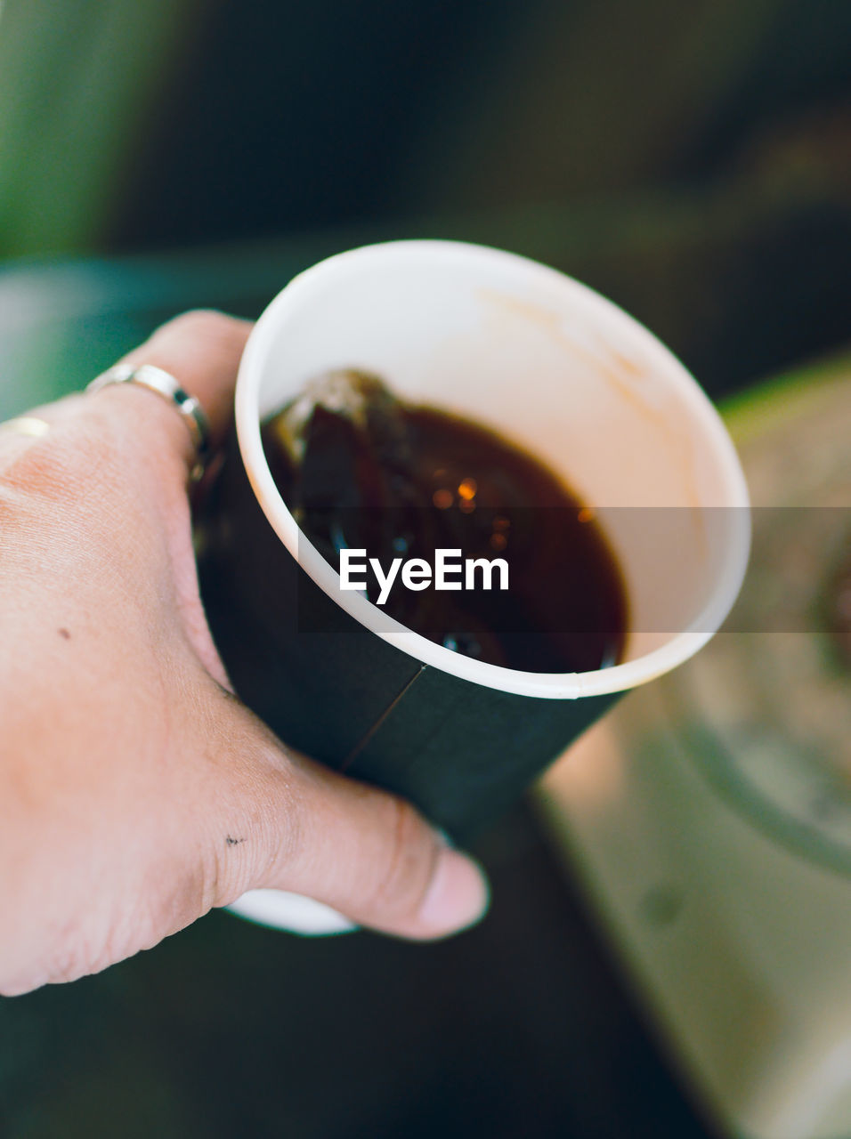 Cropped image of person holding coffee cup