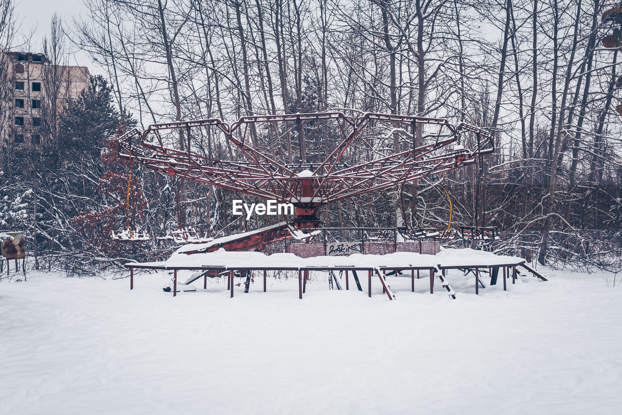 Outdoor play equipment in city against sky during winter