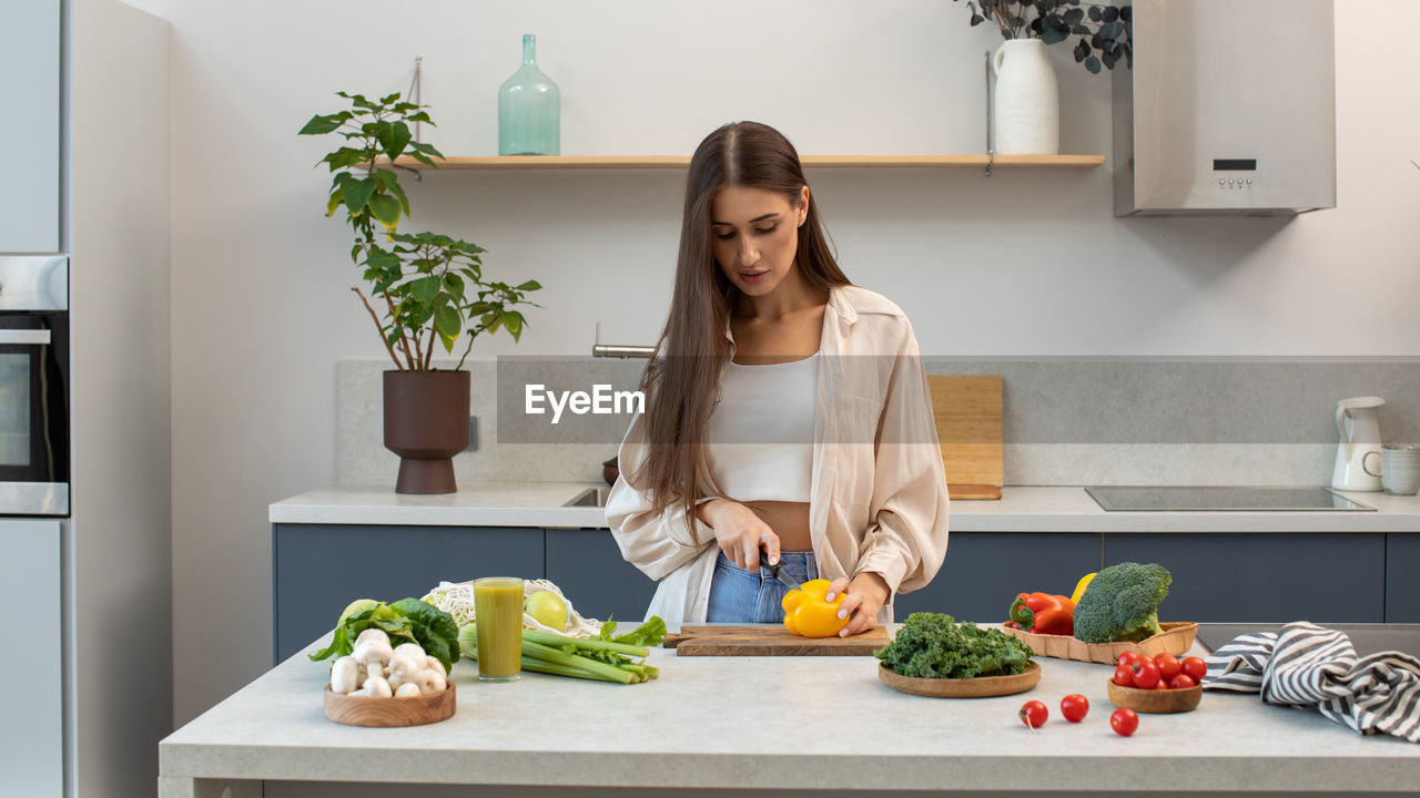 portrait of young woman using mobile phone while sitting at home