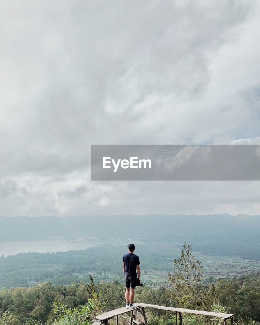 Rear view of man on mountain against sky