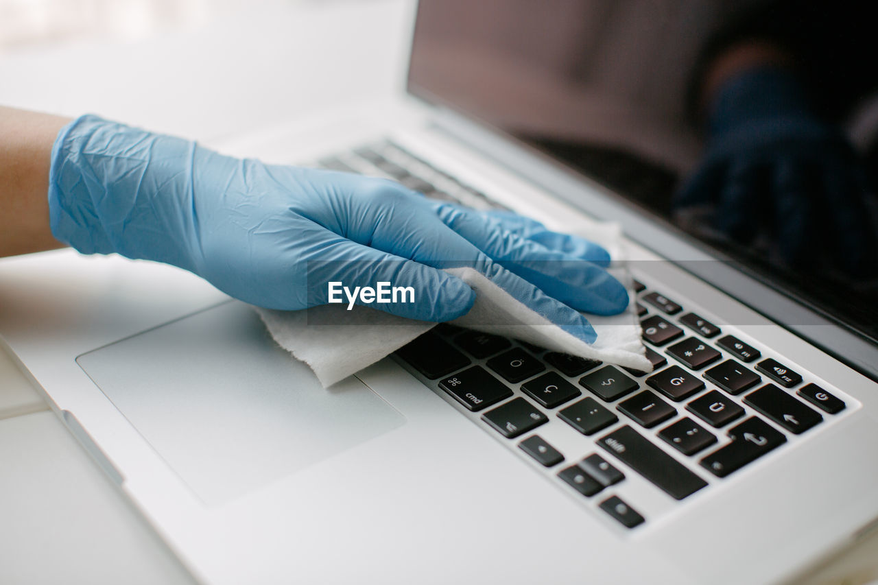 She wipes the keyboard to protect against coronavirus.