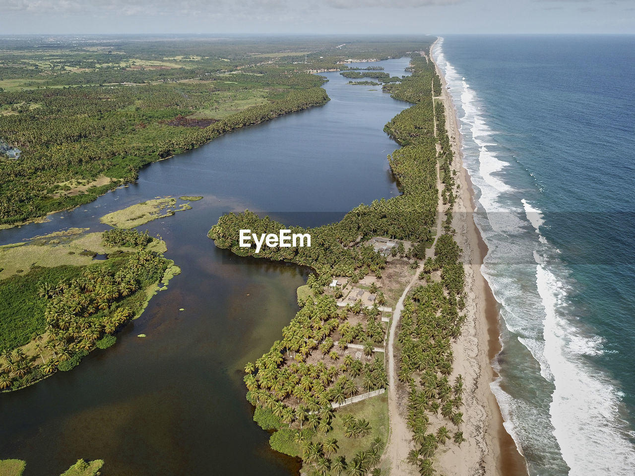 Ivory coast, grand-bassam, aerial view of lagoon surrounded by palm trees