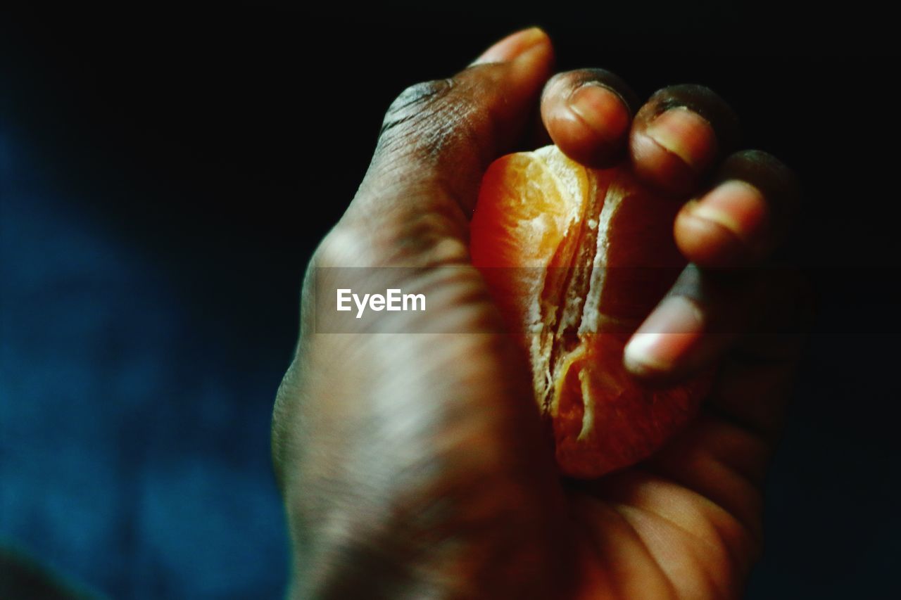 Close-up of hand holding orange fruit