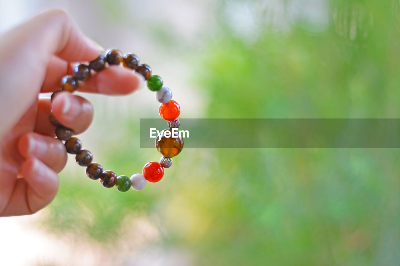 CLOSE-UP OF PERSON HAND HOLDING BERRIES