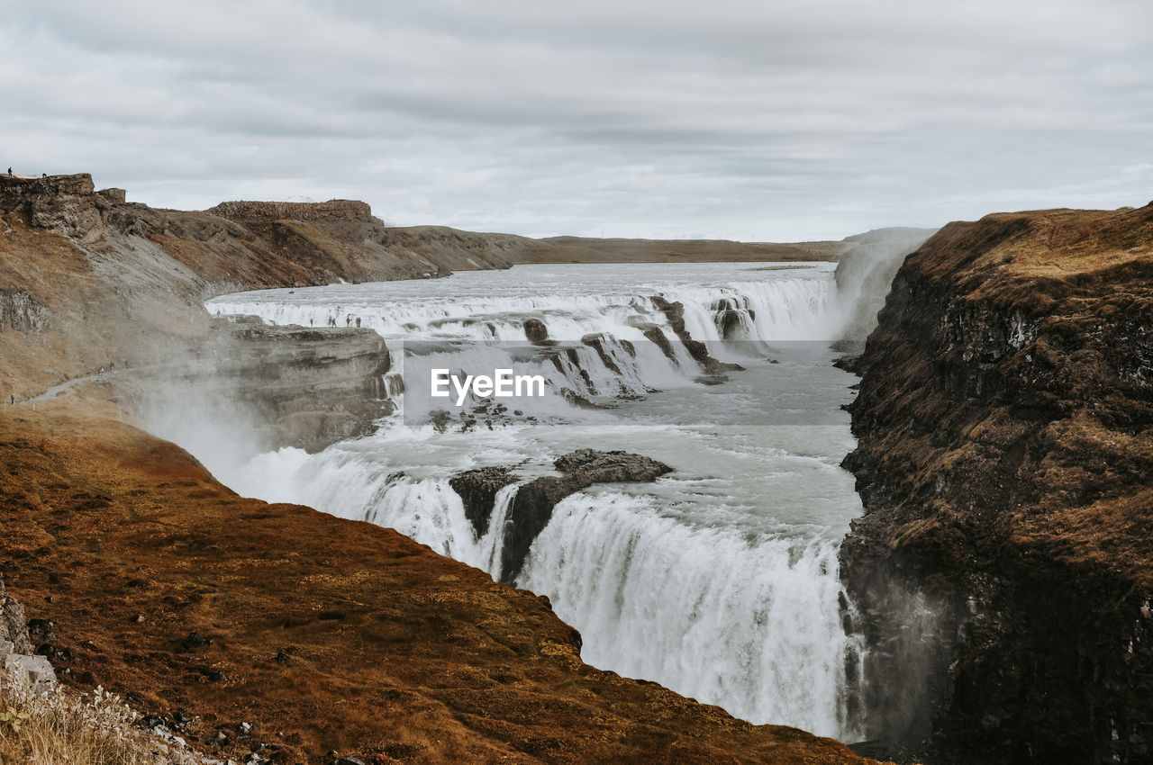 Scenic view of waterfall against sky