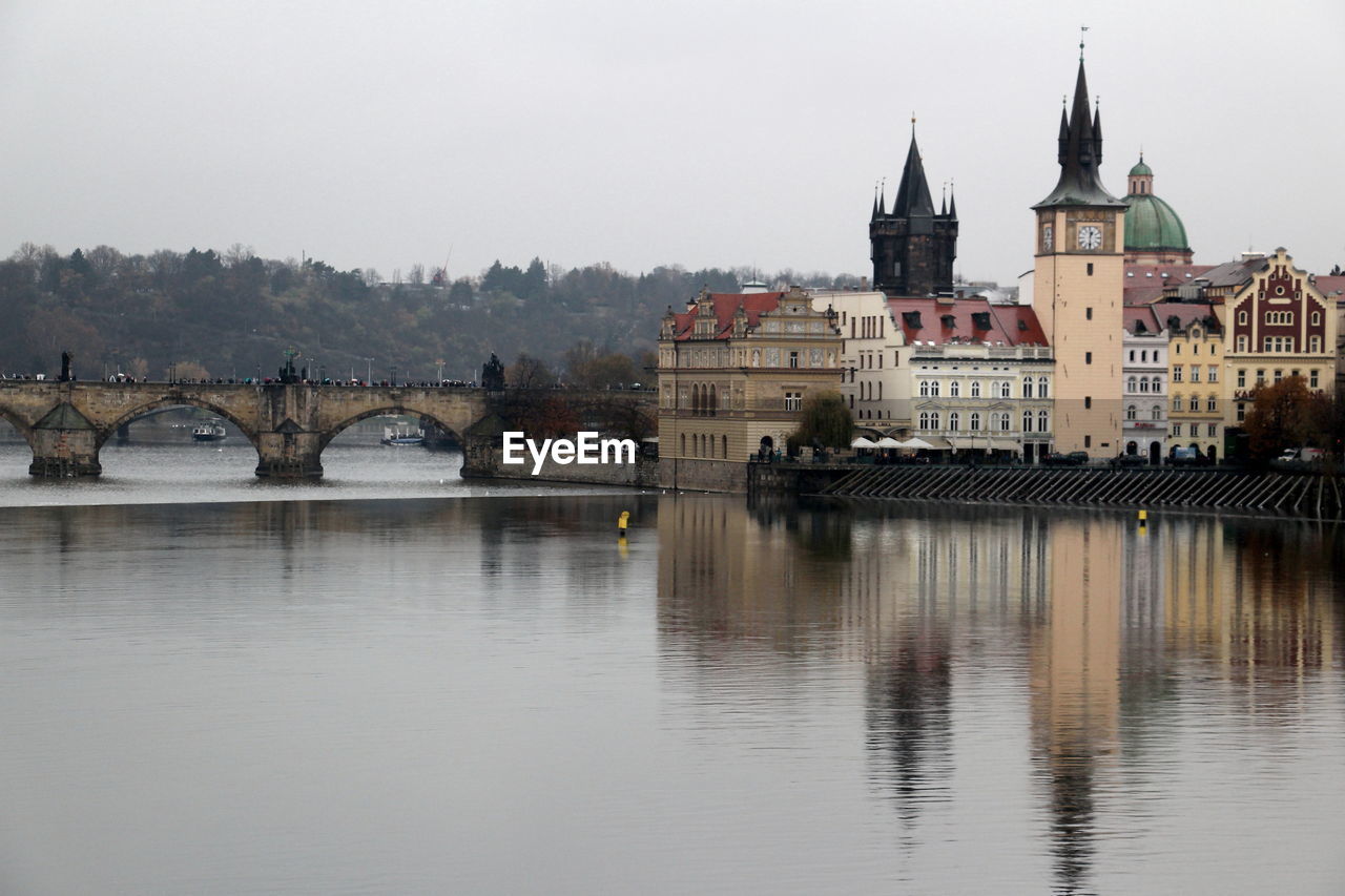 Bridge over river against buildings in city