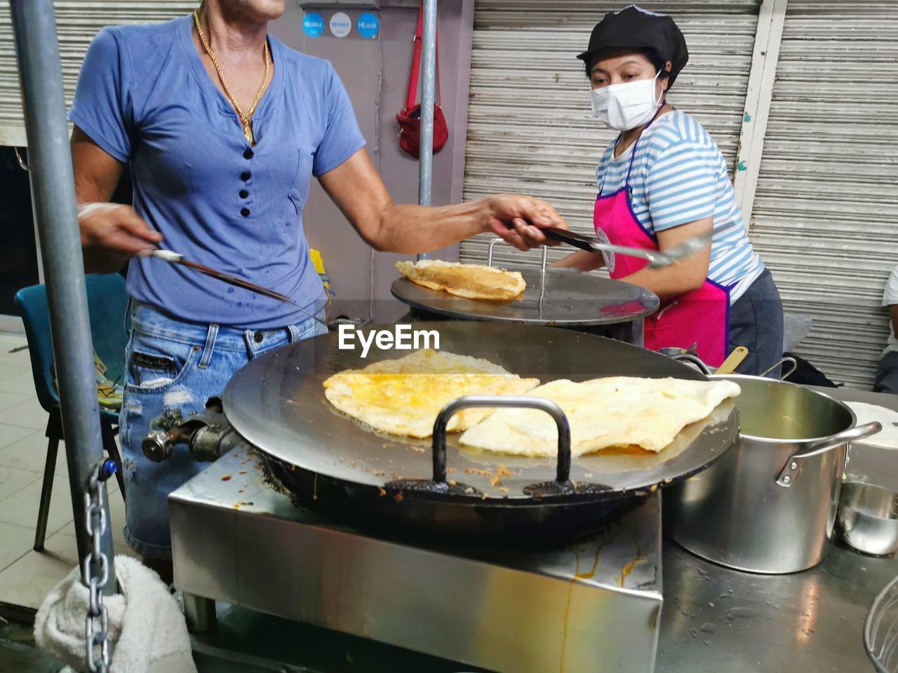 PEOPLE HAVING FOOD IN KITCHEN AT RESTAURANT