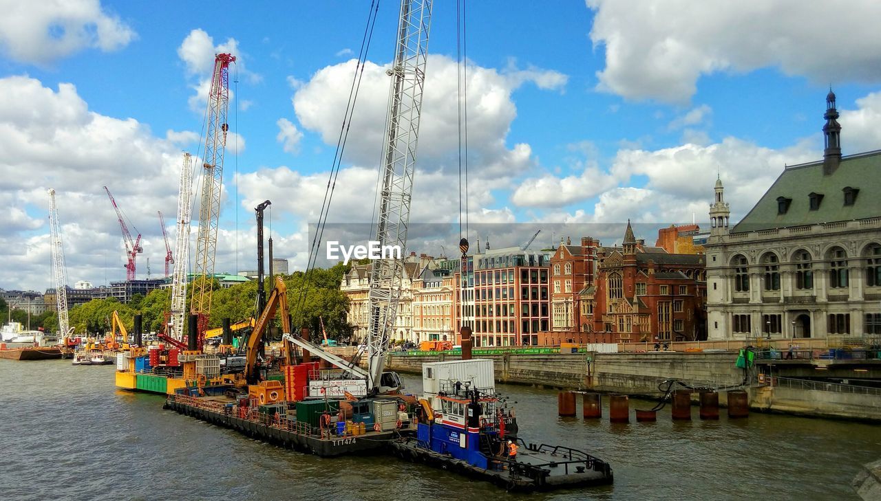 BOATS IN RIVER AGAINST BUILDINGS