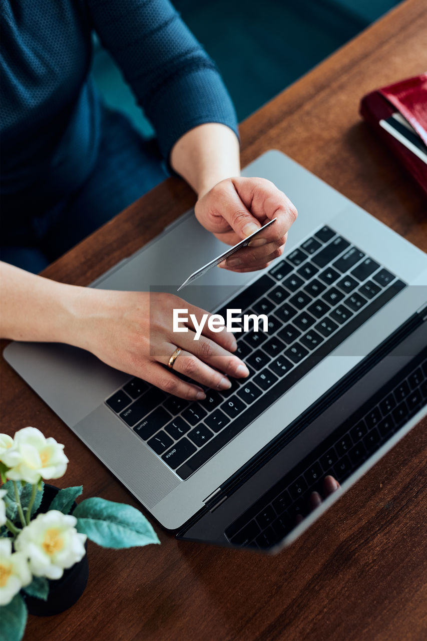 Woman doing online shopping using debit card and laptop. female hands holding credit card