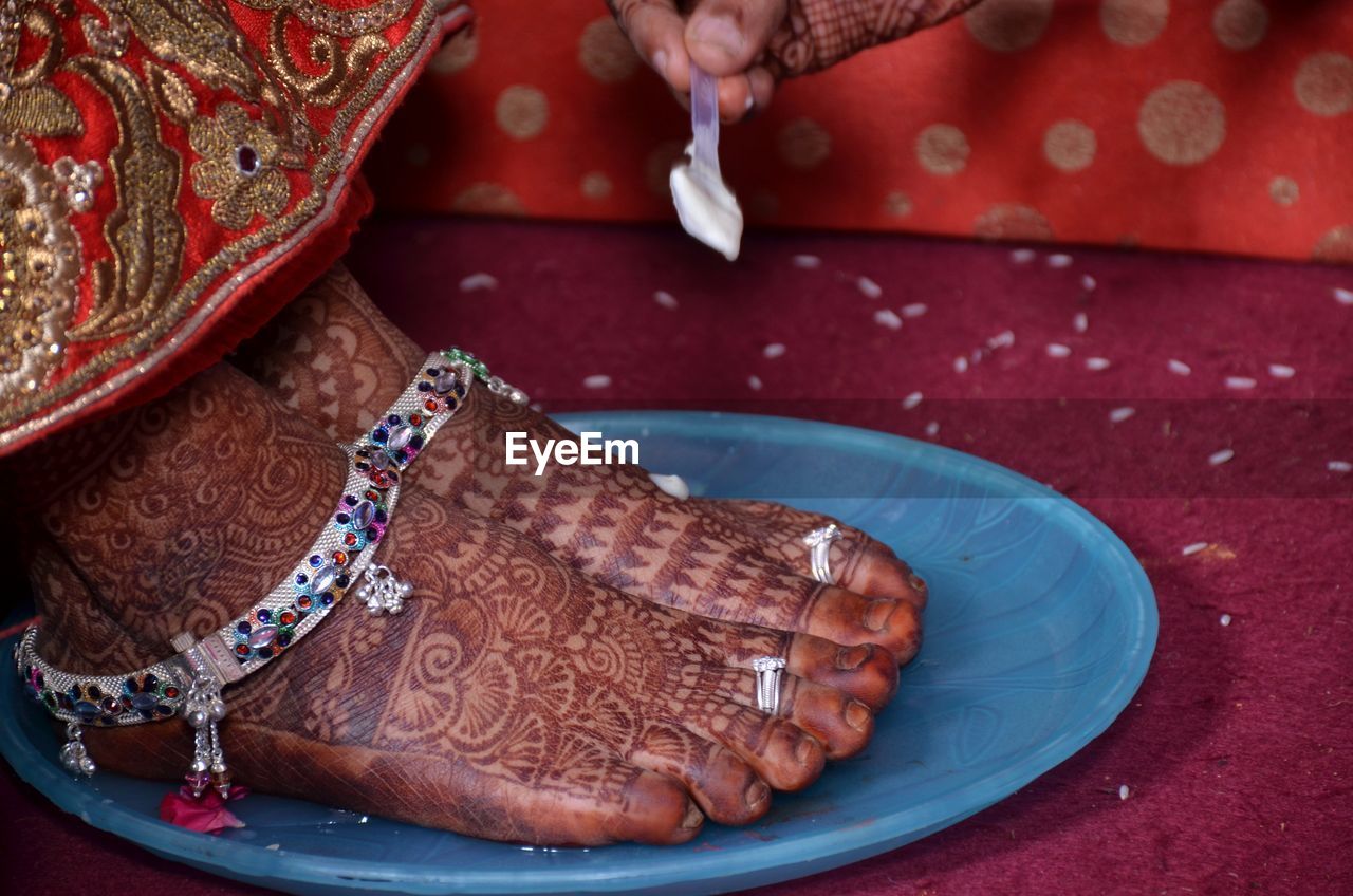 adult, red, one person, hand, traditional clothing, footwear, tradition, women, pattern, henna, jewelry, clothing, henna tattoo, event, celebration, bracelet, life events, close-up, indoors, wedding